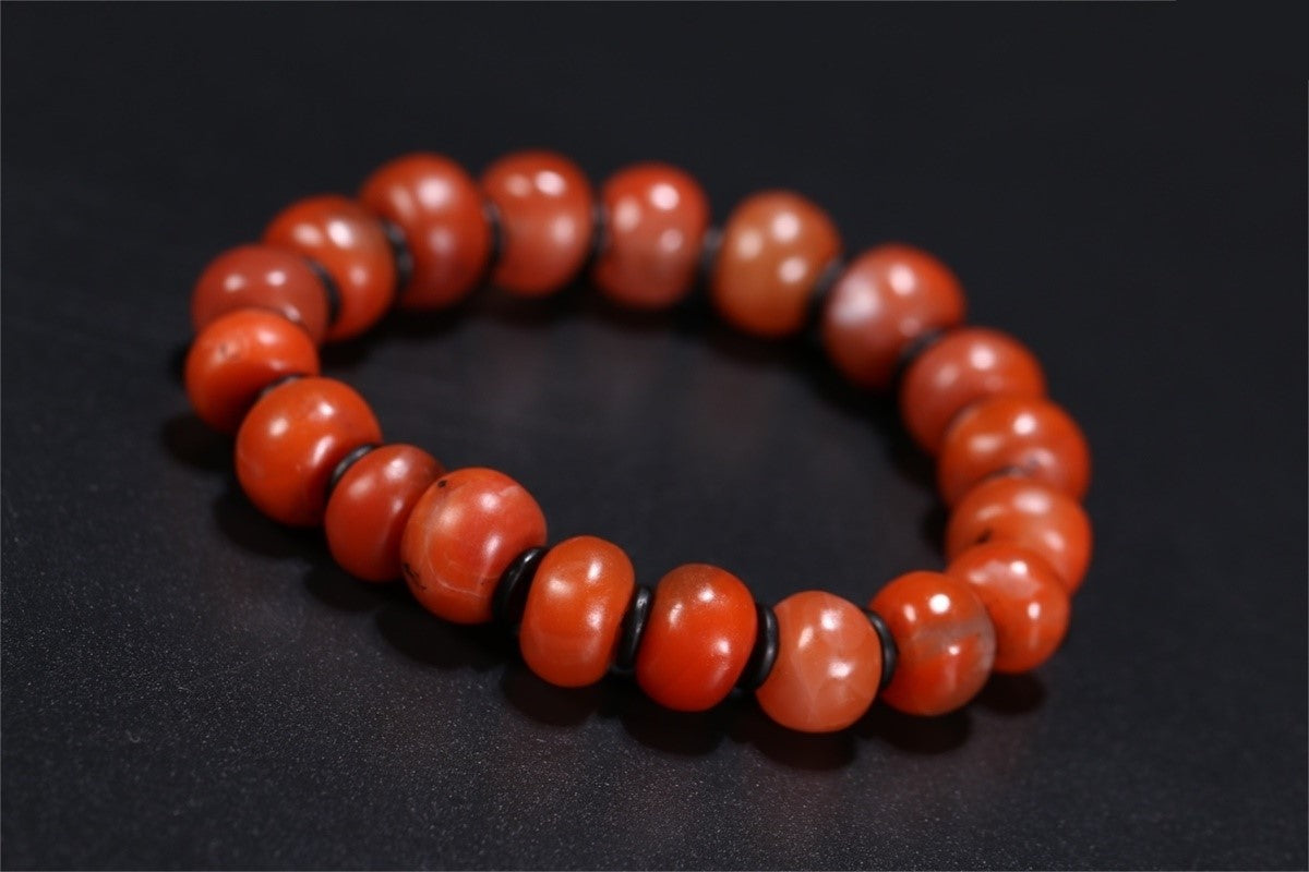 Polished Nan Hong beads showing smooth red surfaces and drilled construction