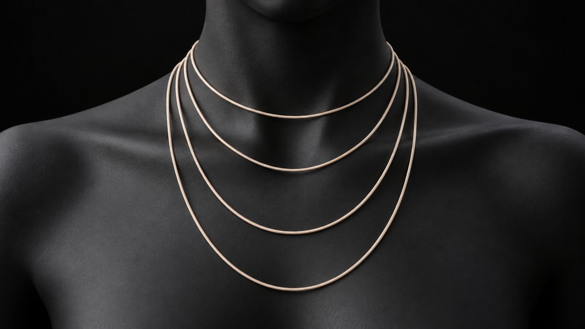 Four plain gold-toned cords hanging at different lengths over a matte-black bust, demonstrating short to longer necklace positions.