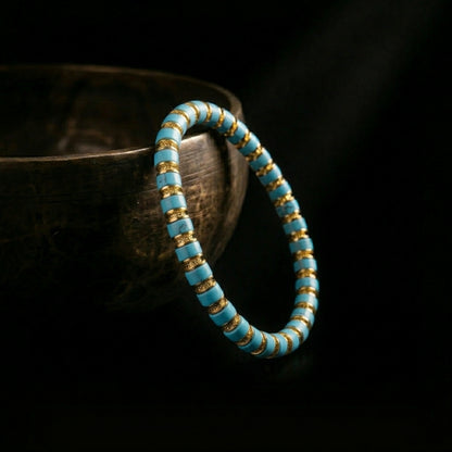 The disc-cut Turquoise grounding bracelet resting beside a traditional singing bowl, capturing the essence of the 1,900-meter acoustic purification.