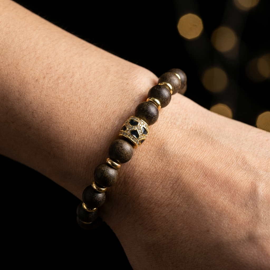 Person touching the intricate enamel bead of their agarwood sensory bracelet, using it as a tactile tool to slow down and relieve time anxiety.