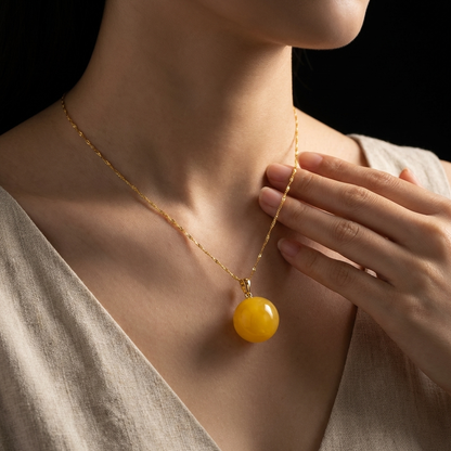Woman wearing the minimalist amber grounding necklace with a neutral V-neck linen top, showcasing modern eastern aesthetic jewelry for everyday anxiety relief.
