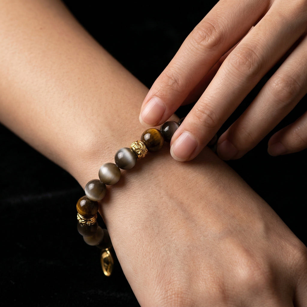 A person tracing the smooth beads of the Tiger's Eye grounding bracelet on their wrist, using it as a tactile worry stone to calm a racing mind.