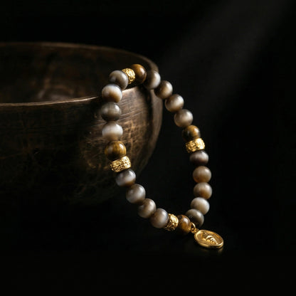 The Tiger's Eye focus bracelet resting next to an antique singing bowl, representing Jambhala's 1,900-meter acoustic purification ritual.