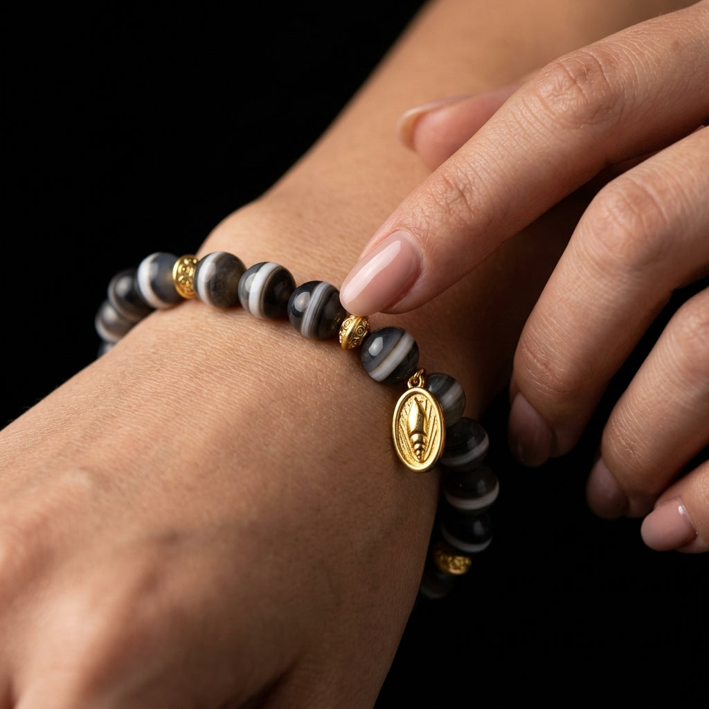 A person tracing the distinct white band of the Single-Line Agate bracelet on their wrist, using the visual horizon to stabilize emotional turbulence.