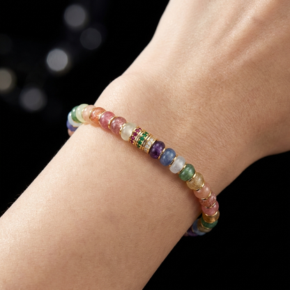 Woman wearing the Lucid Spectrum Multi-Tonal Crystal grounding bracelet on her wrist, showcasing the vibrant disc-cut stones and jeweled gold accents against her skin.