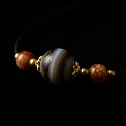 Ultra-smooth 15mm Banded Agate and Tiger's Eye grounding necklace on a black background