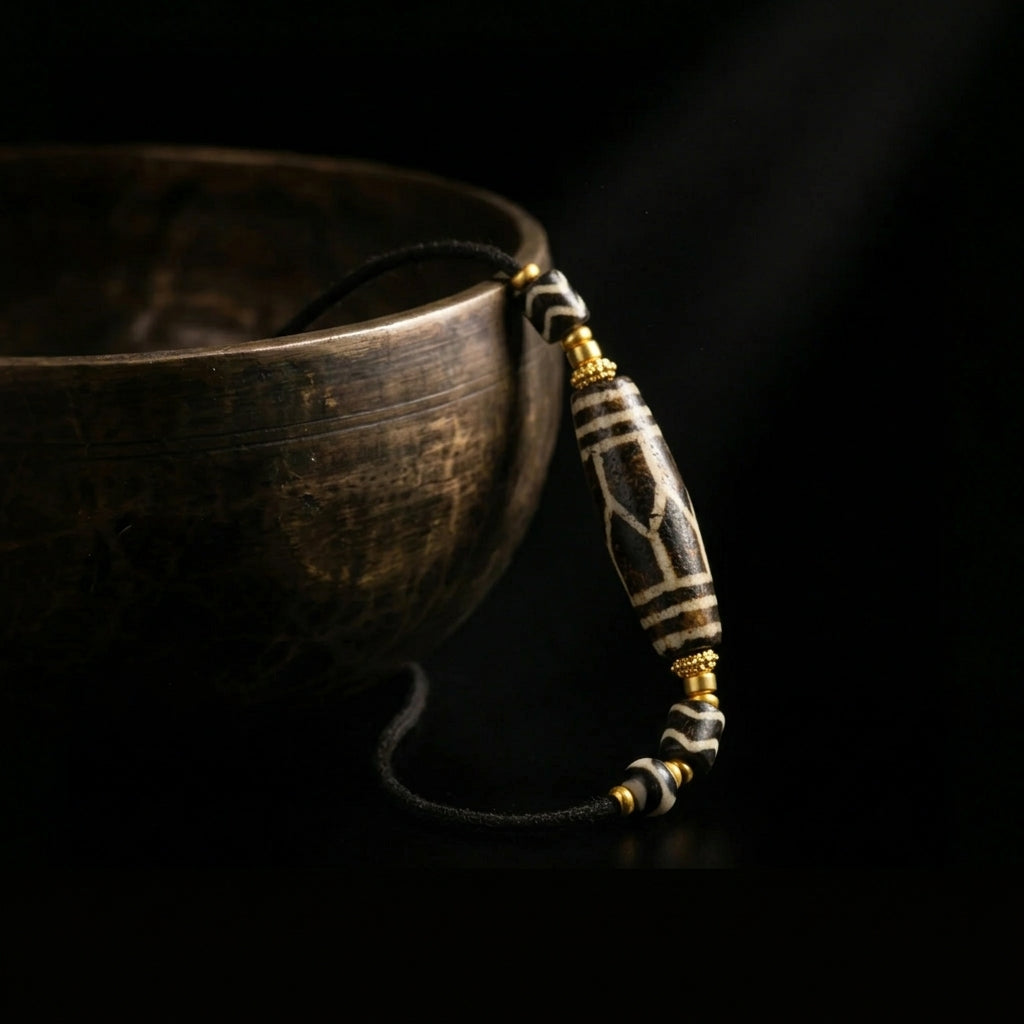 The Petrified Pumtek necklace placed next to an antique singing bowl, illustrating Jambhala's 1,900-meter acoustic purification process.