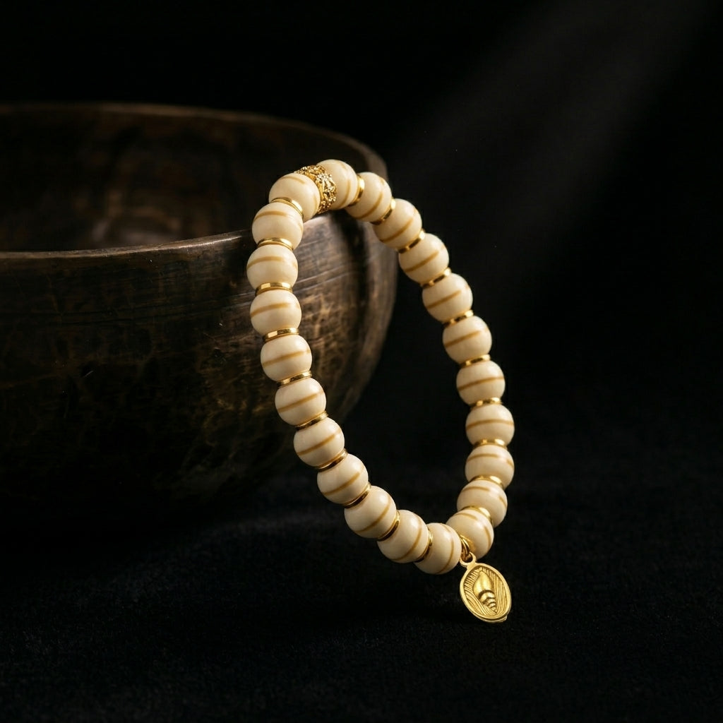 The natural Bodhi seed bracelet placed beside an antique singing bowl, capturing the 1,900-meter acoustic purification process.