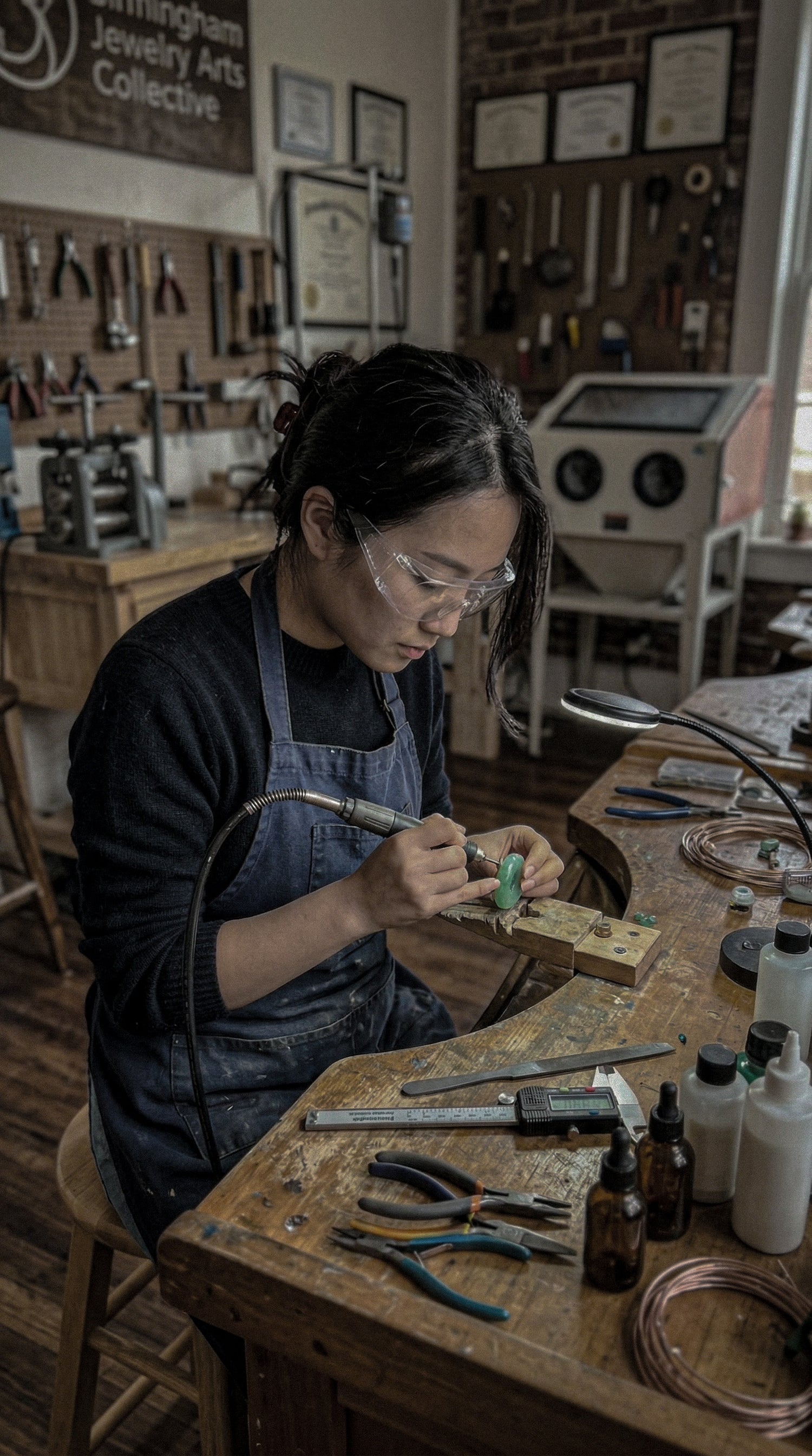 Jambhala founder Fay meticulously polishing authentic natural stones in her Birmingham studio. Capturing the physical craftsmanship required to transform dense minerals into perfectly smooth, tactile grounding anchors for everyday anxiety relief.