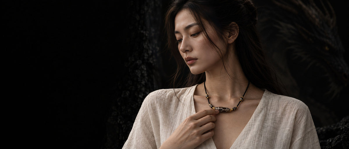 Woman wearing a Jambhala symbolic necklace against a light background.