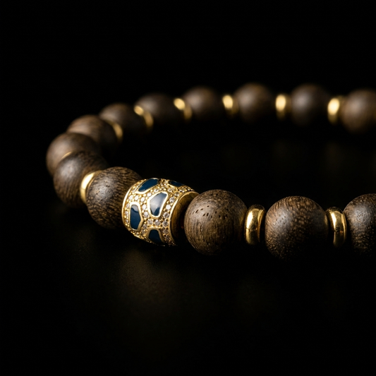 Close-up of the Agarwood focus bracelet, featuring 8.5mm dark resinous wood beads, 18K gold plain spacers, and a midnight blue mosaic enamel focal node with clear pavé crystal borders.