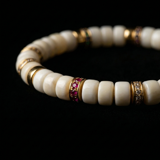 Close-up of the shed antler focus bracelet, featuring 6mm bone-white disc-cut organic beads and 18K gold-plated multi-color pavé focal rings with ruby, emerald, and sapphire crystal accents.